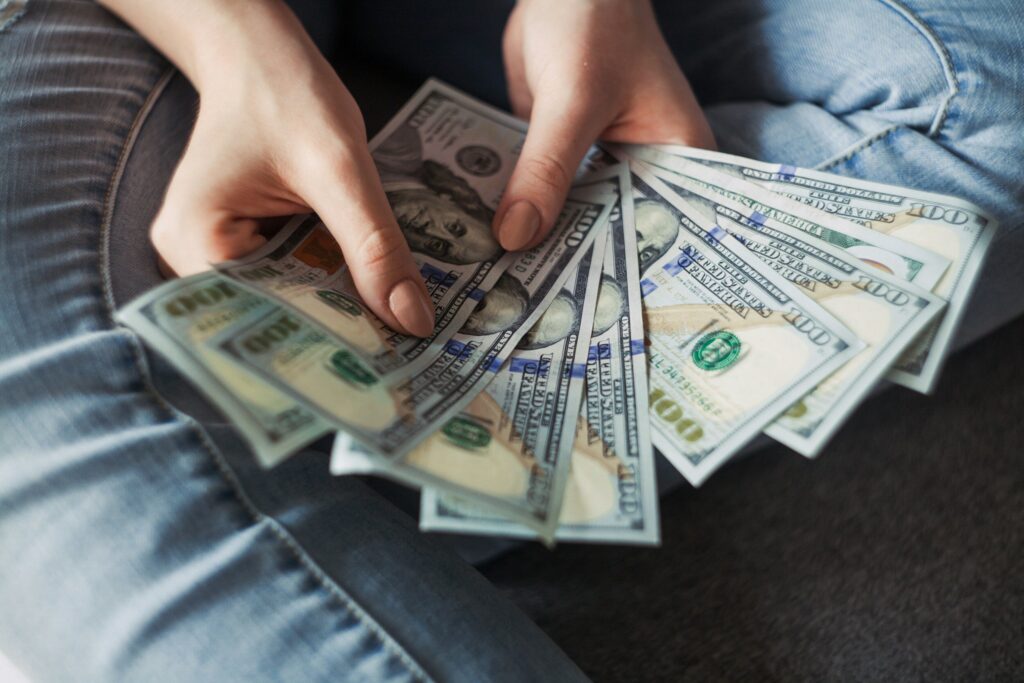 Female Hands Holding US Dollar Bills